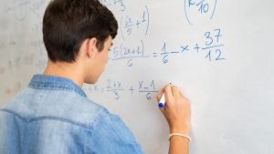 male kid doing ACT math on dry erase board
