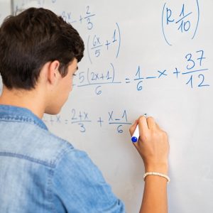 Student Prepares for SAT Math on a dry erase board